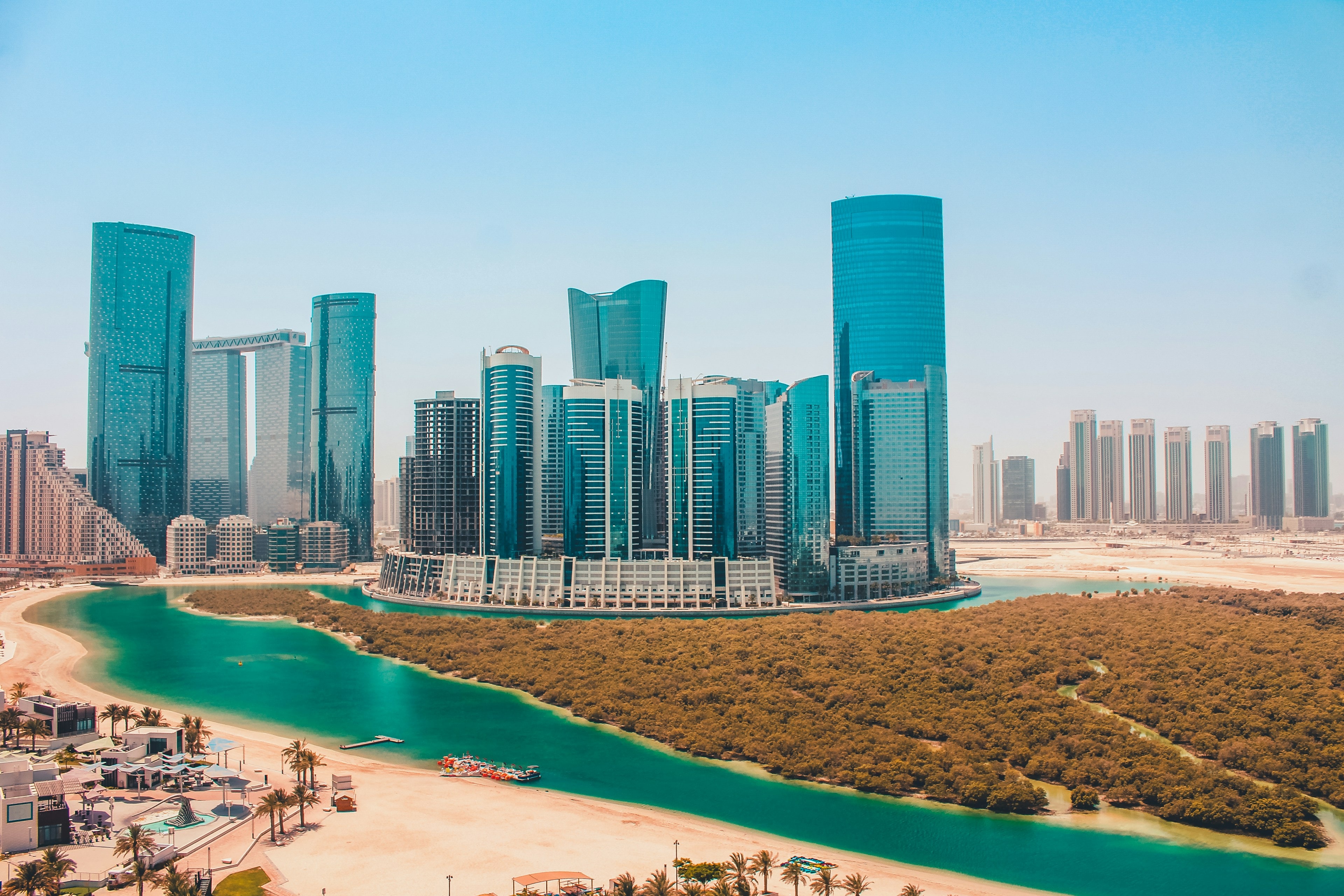 Glass towers on Al Reem Island beside a mangrove-lined lagoon